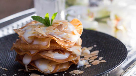 KNAFAOriginaire de Bejaia du temps des Hammadites. Une Pastilla sucrée composée d'une crème Maïzena, lait et d'eau de fleur d'oranger et est accompagnée d'amandes torréfiées. Sa crème originale, médiévale est un peu complexe à réaliser elle est remplacée par celle de la Palouza.
