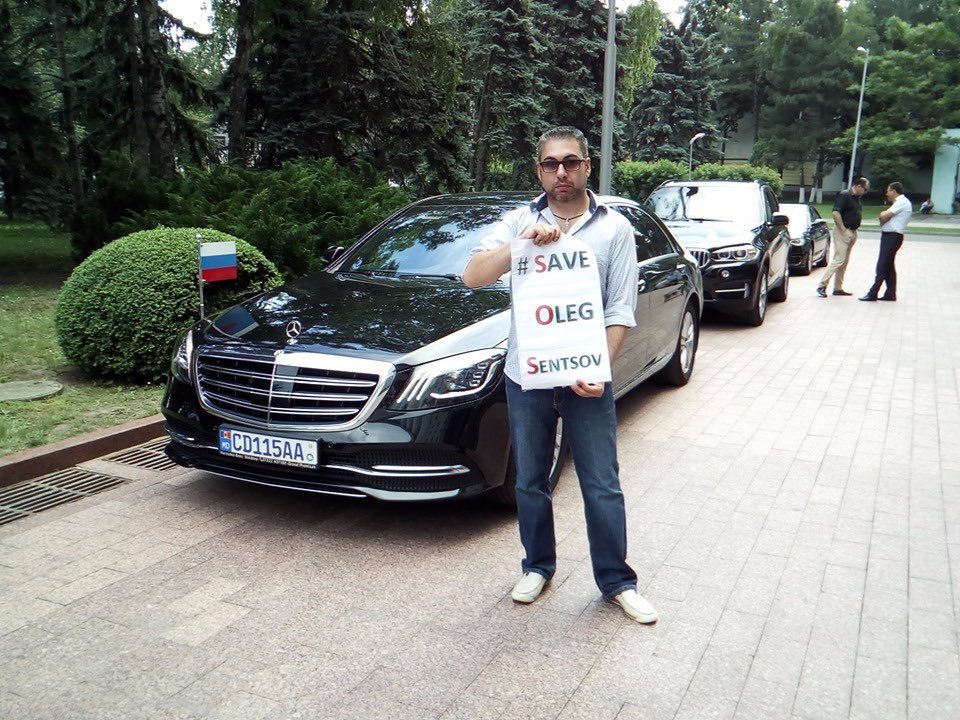 usuprun's tweet image. An activist holding a poster #SaveOlegSentsov blocked the path of the Russian ambassador&apos;s car in Moldova. He demanded the release of Ukrainian political prisoners and #POW’s. It is necessary to use every chance to draw attention to the issue of Ukrainian political prisoners.