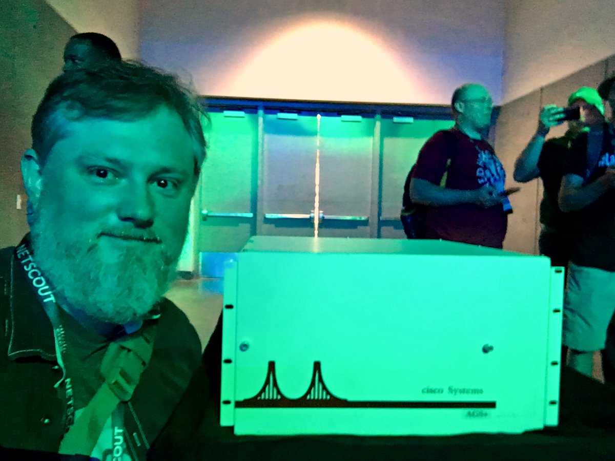 scottm32768's tweet photo. We were under a colored light, but here’s a selfie with an AGS+ from the Cisco archives. #CLUS #CiscoHistory https://t.co/oisDj1JQCL