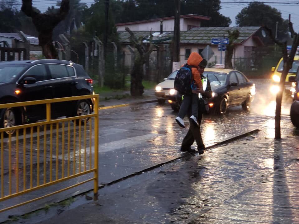tet_planeta's tweet photo. #DESTACAMOS 😎
#Quillon
Apoderados fotografían a carabinero donde muestran que, producto de la lluvia con la finalidad de que los niños no se mojaran sus pies el Teniente Luis Yevenes  los paso uno a uno, quedando completamente empapado producto del clima.
@CarabRegionVIII https://t.co/OUq0uziStw