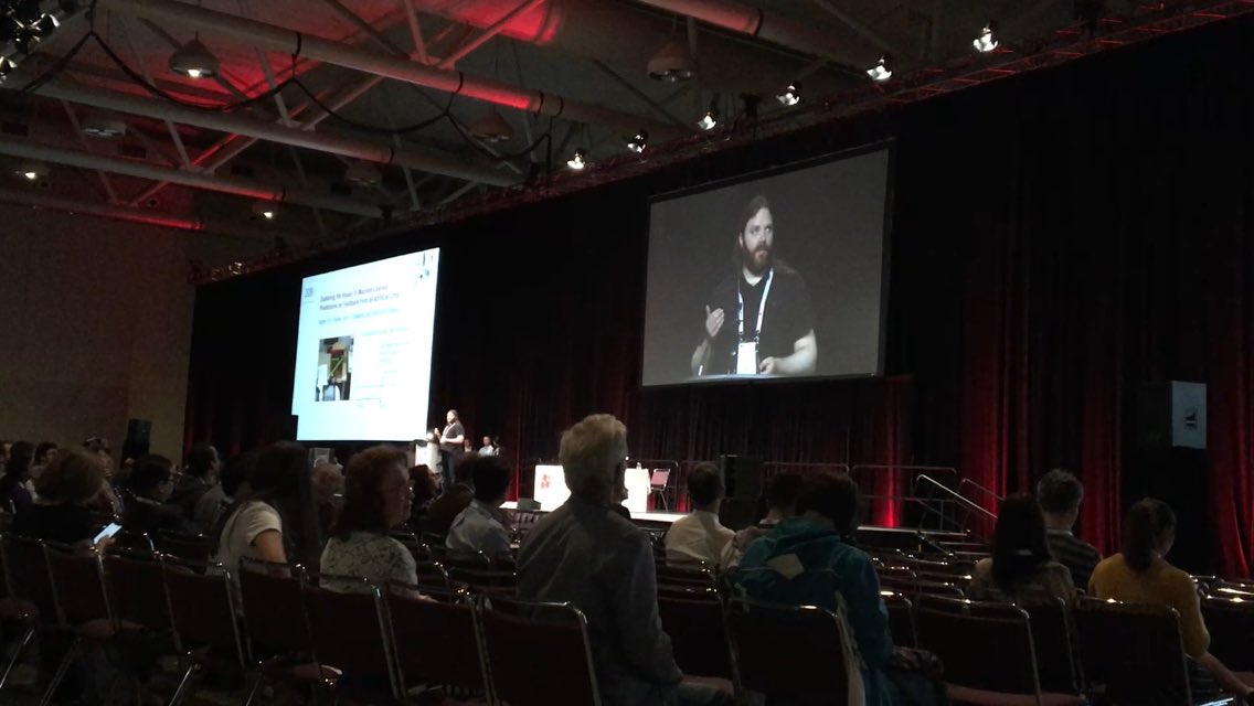 PatrickPilarski's tweet photo. PhD student Adam Parker in front of a packed house at @RehabWeekOrg #RehabWeek2019 sharing his work on using machine-learned predictions in feedback from a robotic limb. #BLINClab @AmiiThinks @SMARTNetwork8 @UAlberta_FoMD https://t.co/lQEHurXaLb