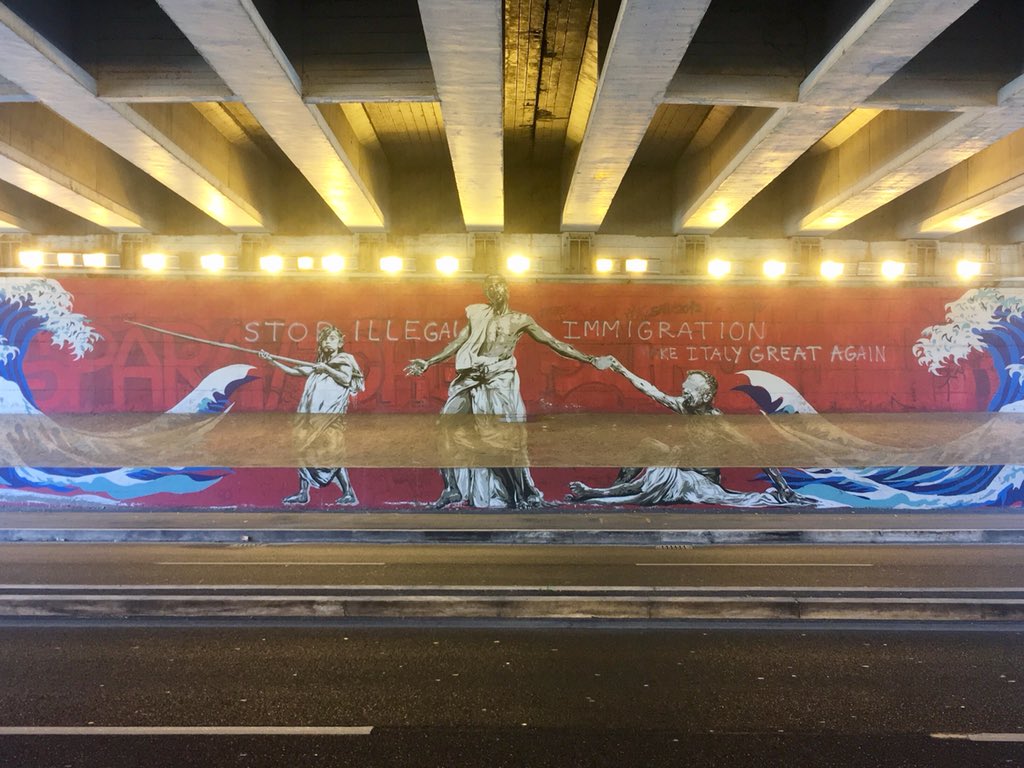 Yesterday I photographed the mural ‘Enea, Anchise, e...’ by <a href="/diavu/">diavù</a>, who used a Somali man as his model for Aeneas. Graffiti on top shows that one person failed to grasp the parallel drawn between the arrival of Trojan exiles to the Italian peninsula and migrations today...