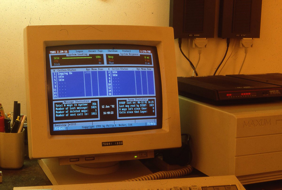 The DOS interface for The Thing BBS on a beige crt computer monitor. Next to the monitor is a computer labeled 'maxum' and several modems.