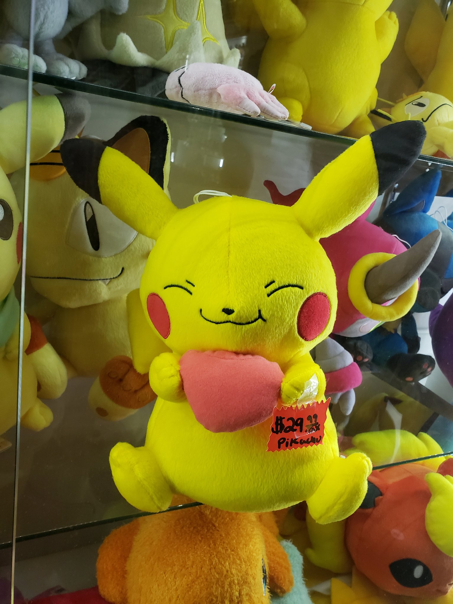 pikachu holding a heart plush