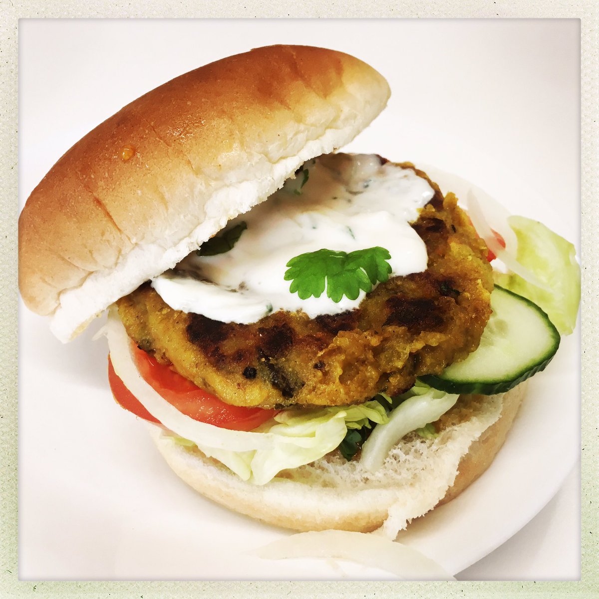 ALOO TIKKI BURGER, indian spiced potato Pattie with salad, mango chutney and raita. Served with hand cut skin on fries, at the cakery today 🌱