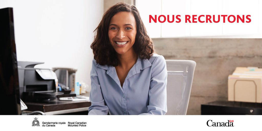 Femme assise à un bureau, souriant. - Nous recrutons
