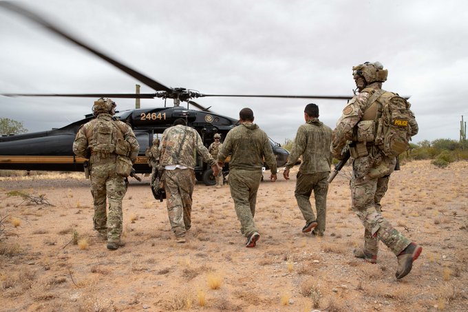 Tucson Sector Border Patrol agents escorting illegal aliens to a CBP helicopter in the remote desert East of Why, AZ