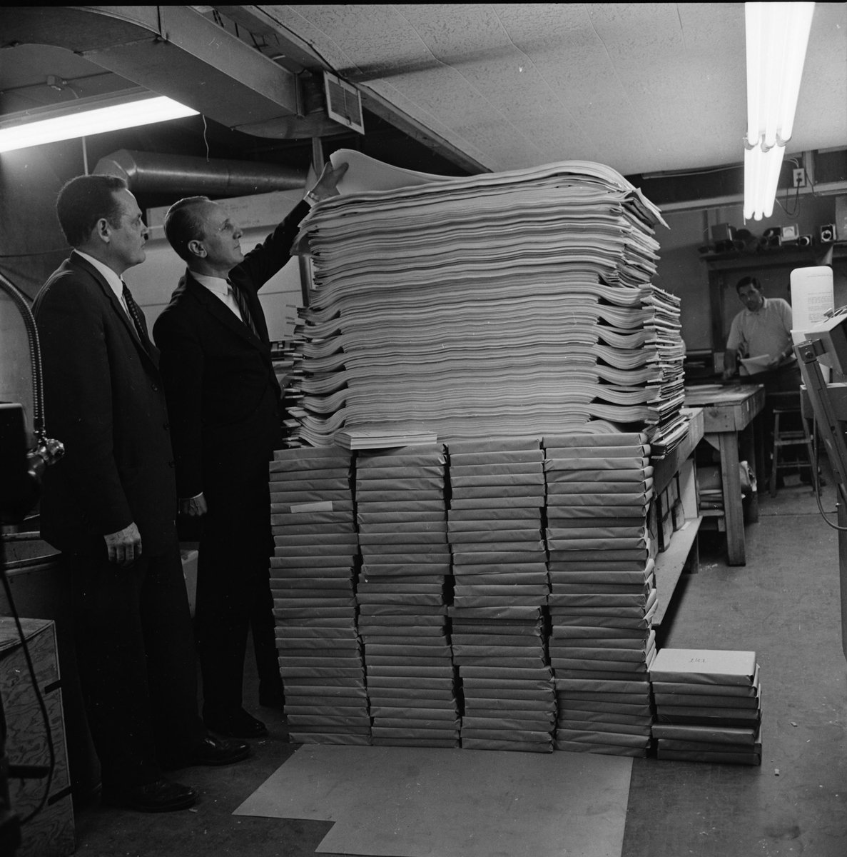 More photos of Huron High and an old photo of Charles Lane standing next to the stack of construction drawings for the new school.