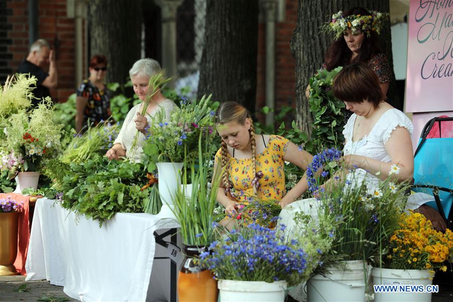 ChinaDaily's tweet photo. People visit the Midsummer festival Ligo market in Riga, Latvia. The annual Midsummer festival Ligo market opened on Friday, during which farmers and craftsmen from across Latvia sell specialties such as rural bread, cheese, traditional tea, honey, handmade cakes and chaplets. https://t.co/wx6poRYSnm
