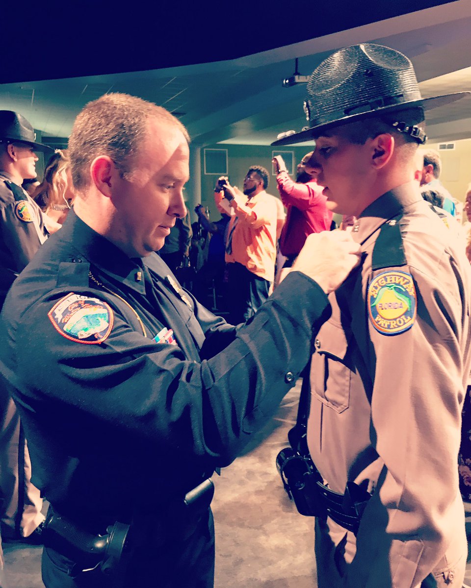 Lt. Minser from <a href="/WHPoliceDept/">Winter Haven Police</a> helps graduate Trooper Hanstine with <a href="/FhpOrlando/">FHP Orlando</a> straighten his newly pinned badge. #OneFamily 💙