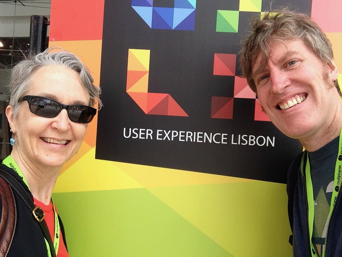 Sarah and Dave selfie in front of User Experience Lisbon poster