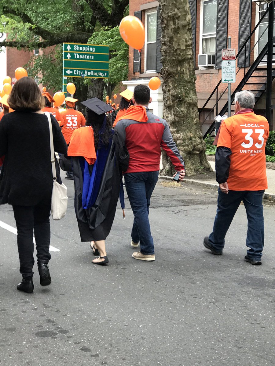 LizShuler's tweet photo. So heartening. #Yale grads taking part in the @33unitehere march. One just swapped her black cap for an orange one! #TheFastAgainstSlow https://t.co/XWr0CFOgJq