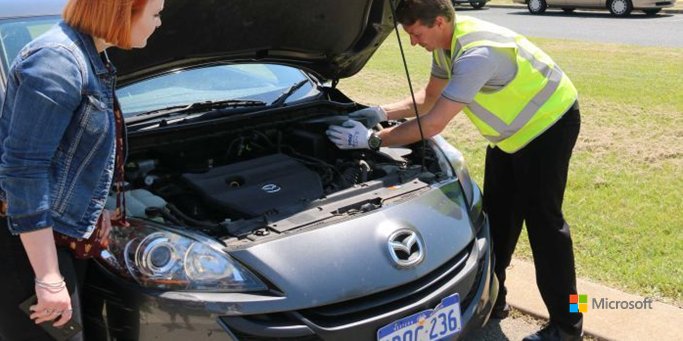 Photo of two people working on a vehicle
