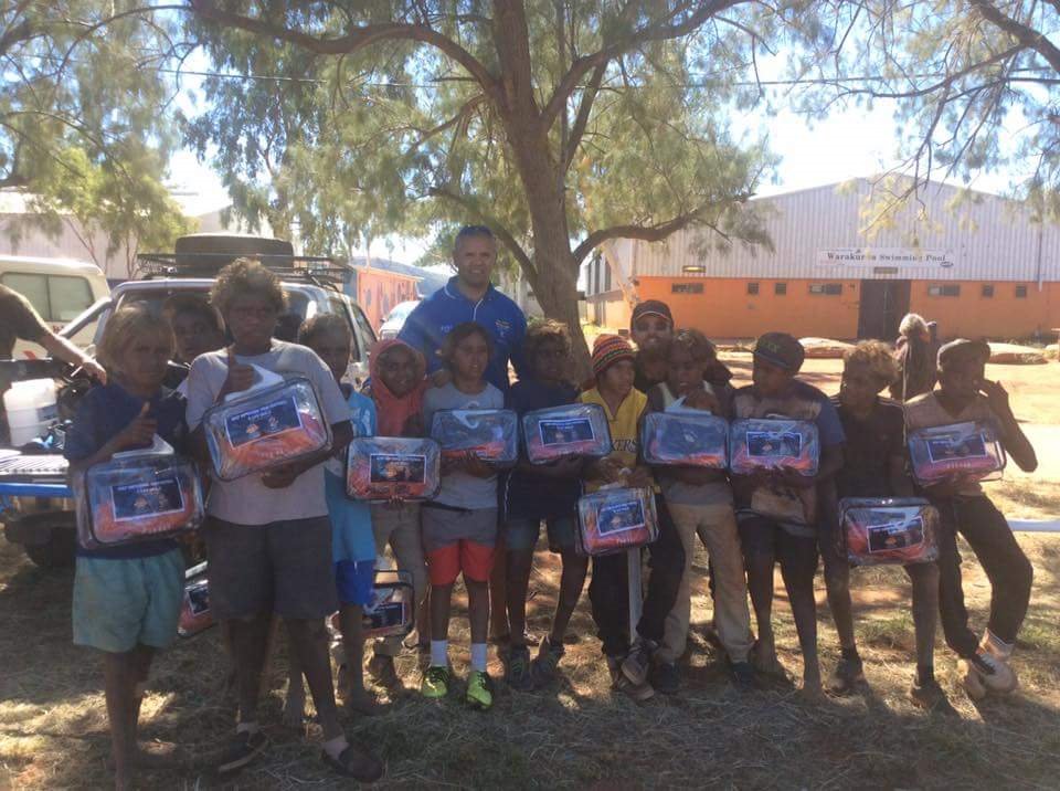 OIC of Warakurna with some of the kids who participated in a recent footy match at Warakurna Community