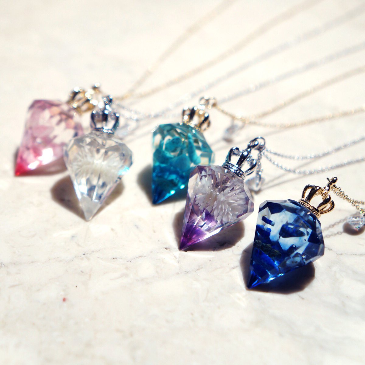 ストーンマーケット New クリスタルレジン パワーストーンアクセサリー きらきらと透明感のあるクリスタルレジンの中に 色とりどりの天然石を封じ込めました 光にあたると美しくきらめきます ネックレス1500円 ピアス1800円 ご用意