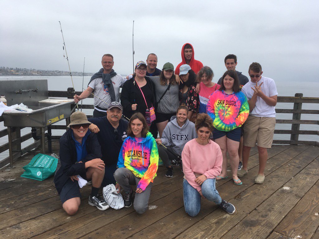 Teaching a young group of Canadians how to fish at the Oceanside's pier with Uncle Bill from the bait shop