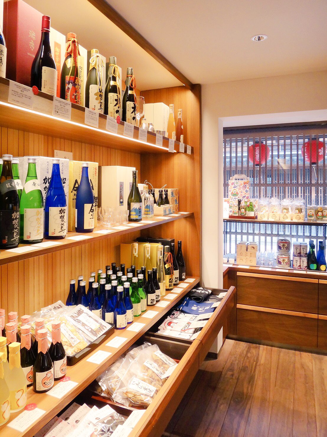 Sake Shop 福光屋 ひがし ひがし店はひがし茶屋街のメインストリートにあります お土産コーナーには お酒はもちろんのこと おつまみや酒粕スイーツ おちょこや器など様々な金沢らしいものを取り揃えております 目印はお店の前の酒樽です お気軽にお