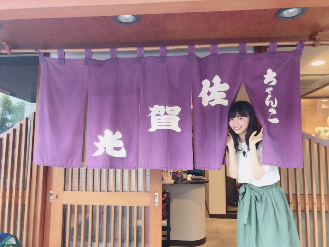 のれんから顔を出す山根千佳