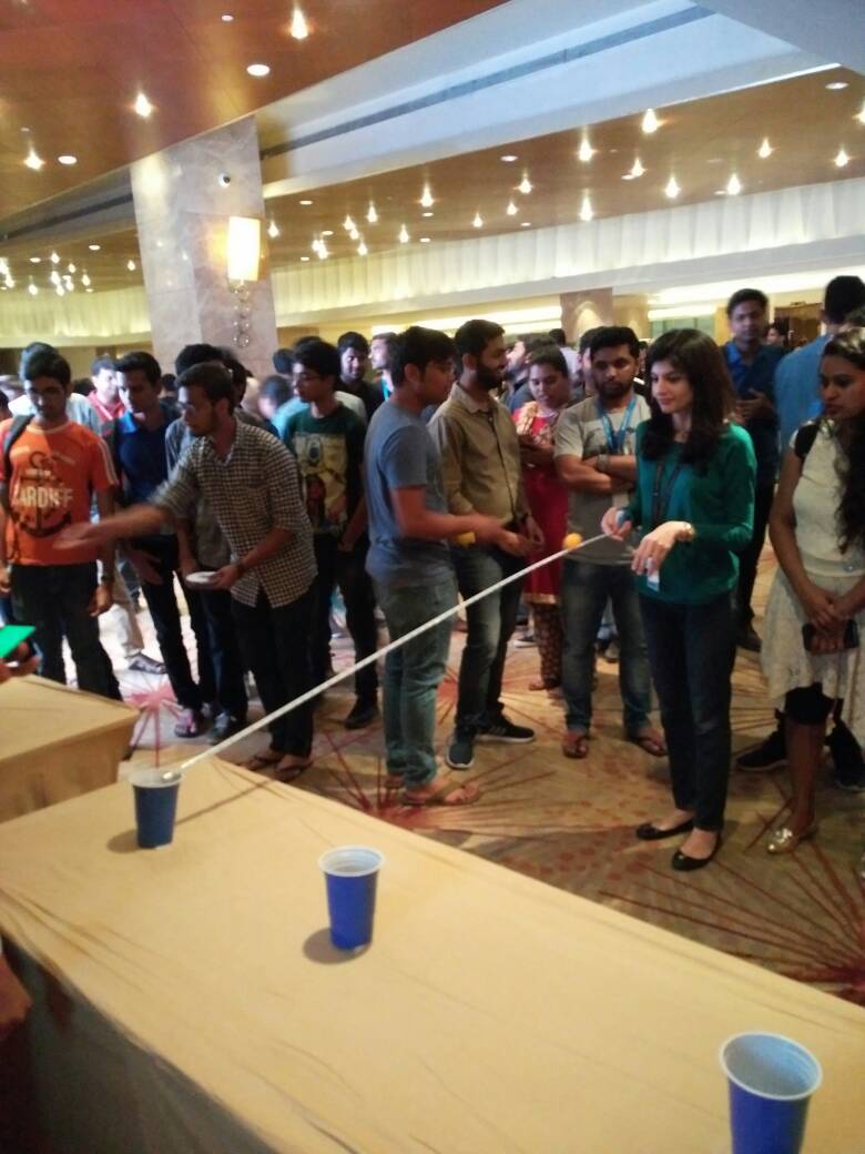 AmazonNews_IN's tweet photo. The excitement is palpable! Look at these Amazonians trying to pot balls into glasses using a tape. #GameOnAmazon alright! https://t.co/OVXHLyje4r