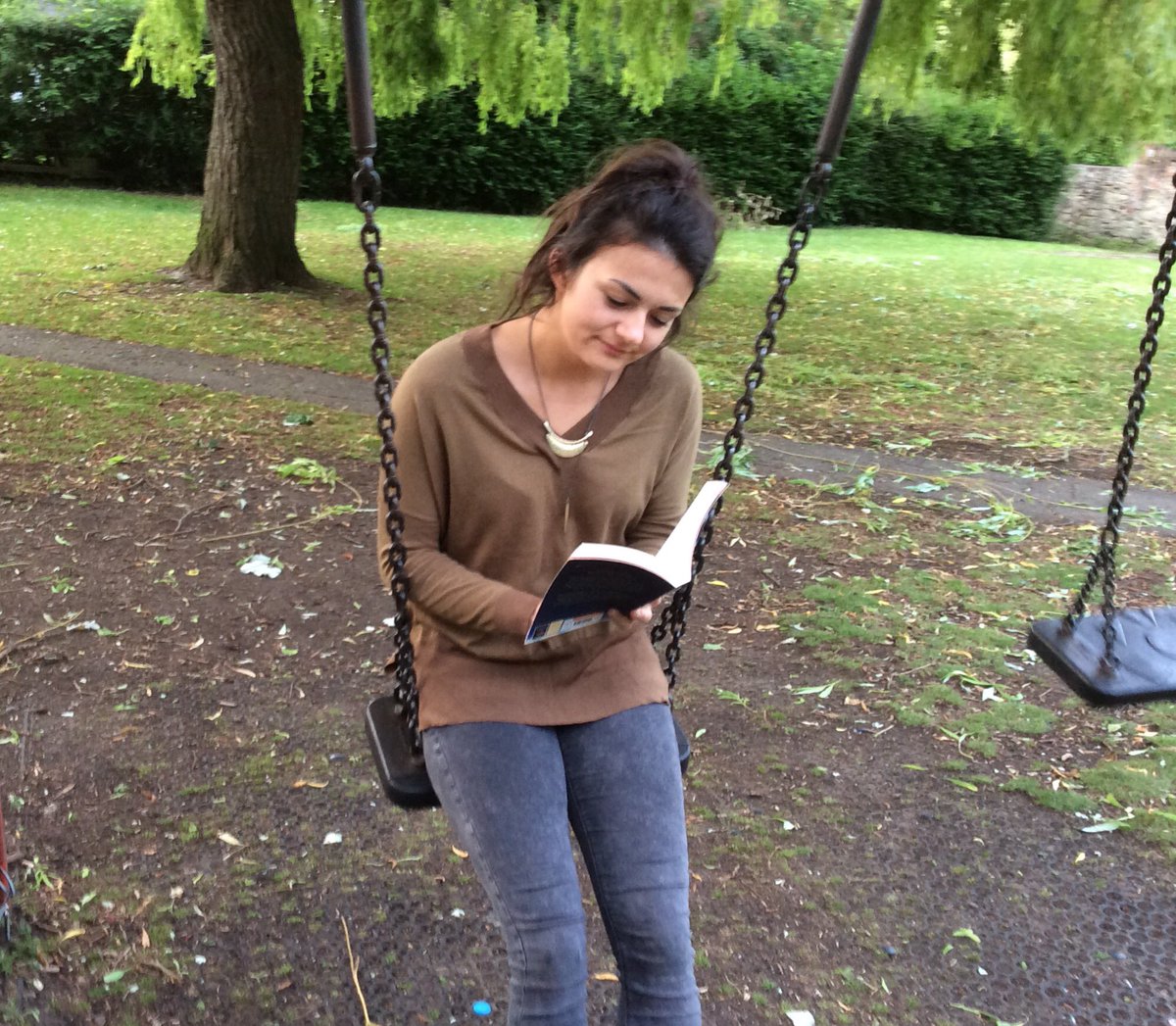 Y6Jesmond's tweet photo. Miss Perry enjoying a book on the swings #jgreading https://t.co/qZCPyjGu4m