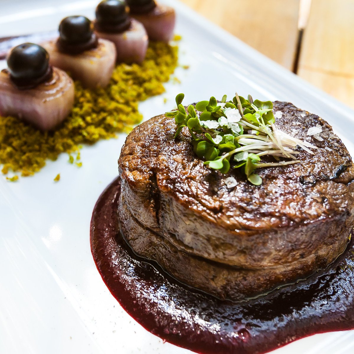 Solomillo de buey relleno de queso de cabra y espinacas, acompañado con migas de finas hierbas y salsa de cassis 🍒🌿🧀 #bocagrandebcn