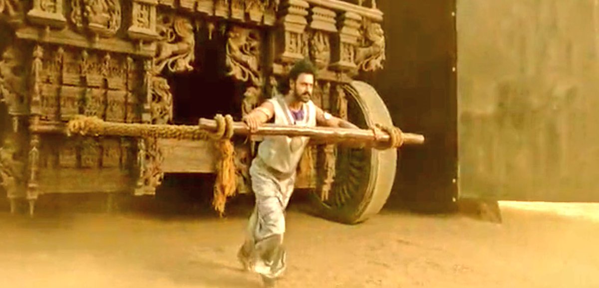 Amarendra & Mahendra carrying gods to safeguard their mother. Father(Amarendra) carrying son(Ganesha) & son(Mahendra) carrying father(Shiva)