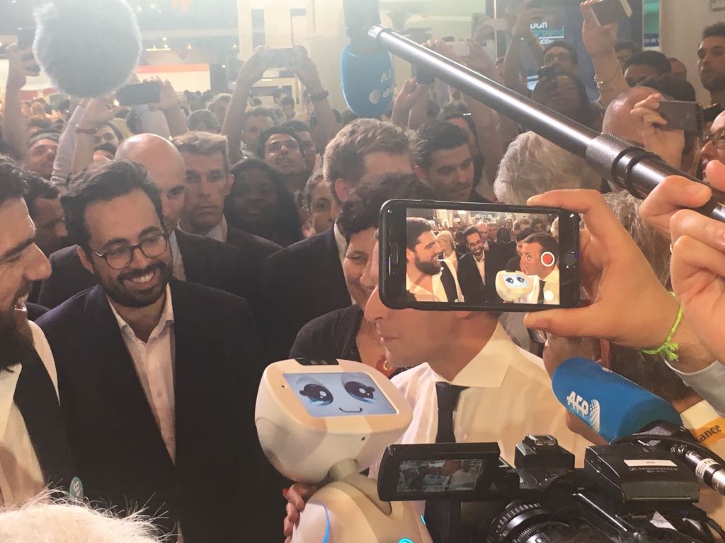 adoptbuddy's tweet photo. Buddy, the companion #robot imagined by @Hasselvander_R, CEO of Blue Frog, in the arms of the French president @EmmanuelMacron #VivaTech https://t.co/upNp3ZLJlh
