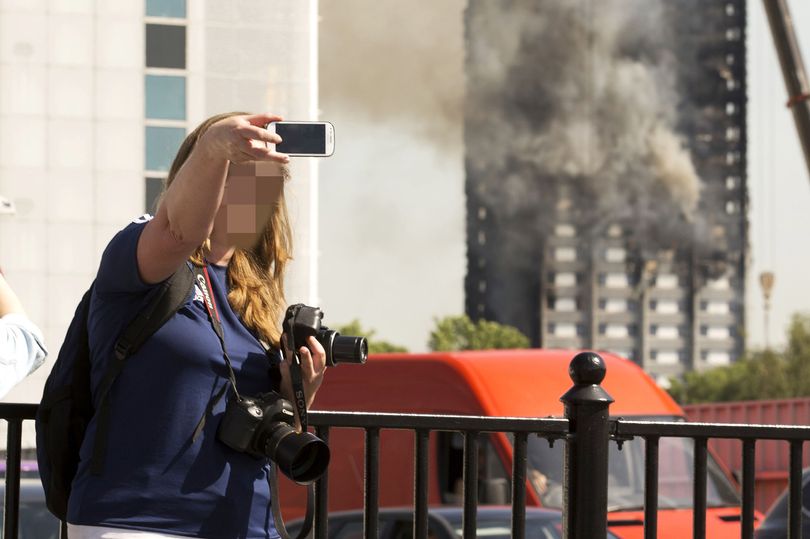 DailyMirror's tweet photo. Sick ghouls pose for selfies in front of Grenfell Tower as bodies of victims lie inside https://t.co/7LRmkMI5vW https://t.co/HPu0N3heBB