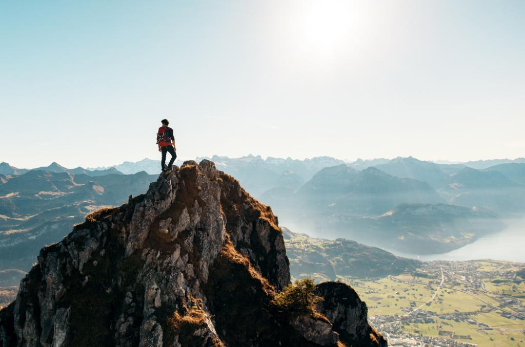 Hiker on the top of a cliff overlooking a valley