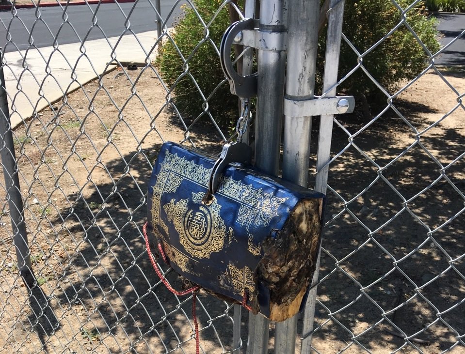 AMJLPVCE's tweet photo. A burned Quran filled with bacon handcuff from a temporary fence outside the Masjid Annur Islamic Center IN Sacramento.R we still human? https://t.co/LRmJHlgMoI