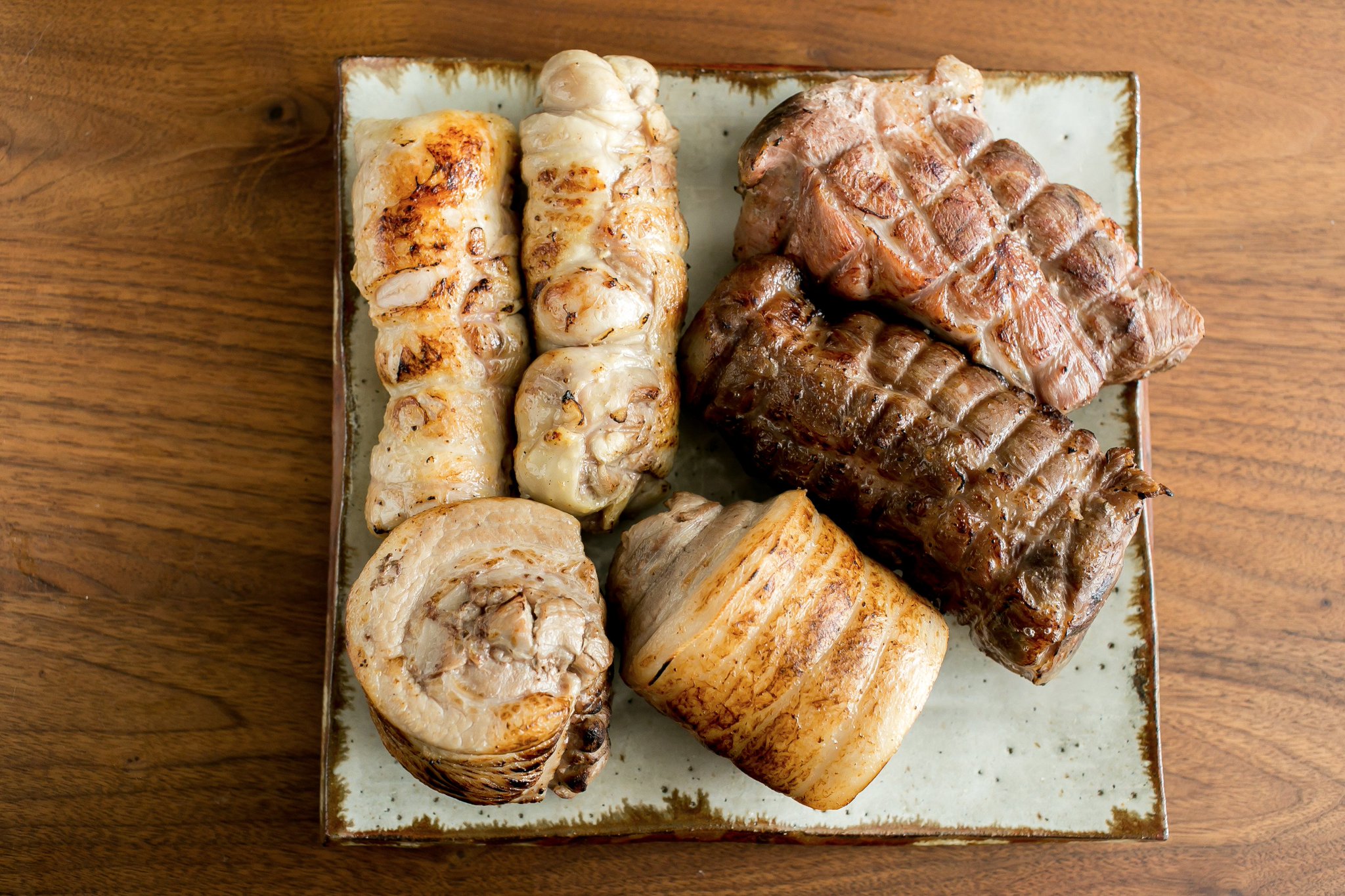 ぶち猫 チャーシューは四種類で 順番に豚骨スープに沈めて加熱した豚バラの丸チャーシュー 豚肩ロースの昆布出汁シンプル チャーシュー 花椒や八角を使ったスパイシーな豚肩ロースチャーシュー 鶏もも肉低温調理チャーシュー いずれも表面をバーナーで