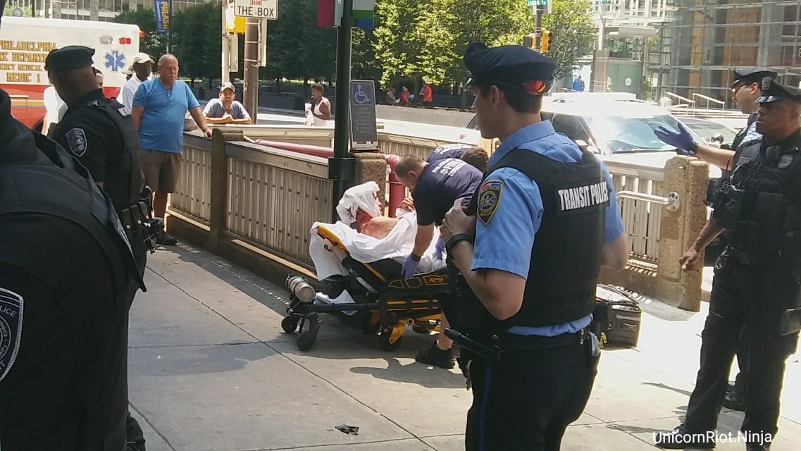 UR_Ninja's tweet photo. Man with 'Trump 2020' sign at Philly march/rally w Nazi flags, speeches for 'white ethnostate' later carried away on stretcher by paramedics https://t.co/wQyxYS4E7V