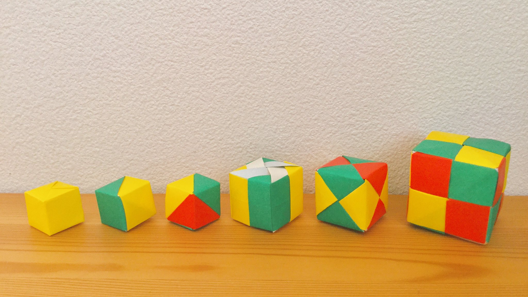 Origami 折り紙のいいところ 1枚でも作れる 2枚でも 3枚でも 枚でも作れる ユニット折り紙 新しい世界のたのしみ 布施知子 著 おりがみ ねじり折り プロジェクトf 編 より立方体 正六面体 左から藤本キューブ 1枚 2枚組 3枚組 4