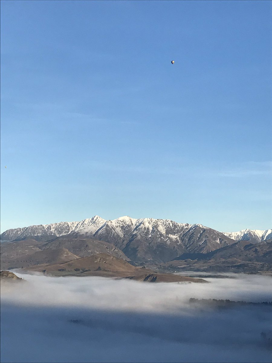 trudinelson's tweet photo. Here's why no flights can get into @NZQN this morning. Thick #fog over Queenstown. Spot the #hotair balloon @WeatherWatchNZ #CrownRange 🎈⛅️ https://t.co/Eg1qjqg72y