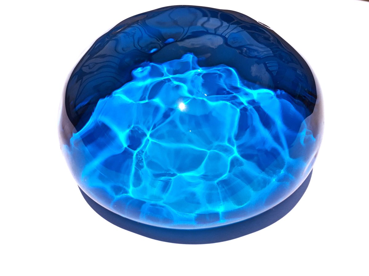 吹きガラス作家 小野省三さんの 光模様のペーパーウェイト が届いた とにかく綺麗 光源によって全く表情が変わり 自然光で照らすと海をすくい取ったような光の模様が現れてずっと見ていられる ガラスから落ちる光も美しい 原稿で海に行けなくたってこれで