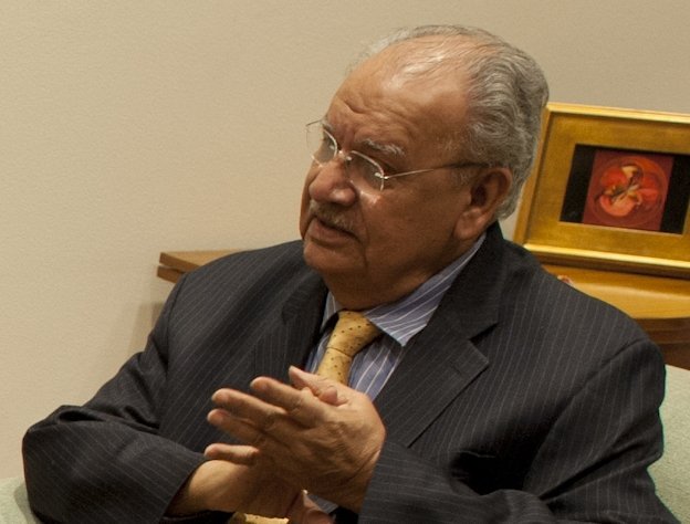 Naresh Chandra seated indoors wearing a pinstripe suit and glasses in 2017.