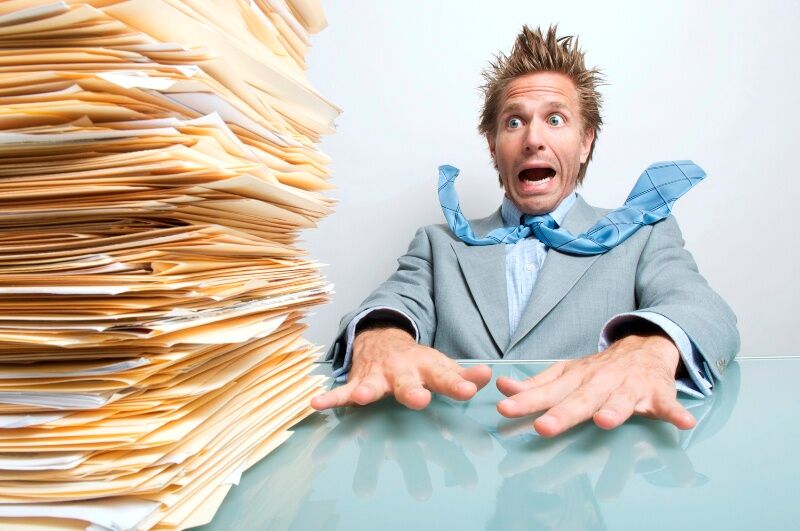 Женщина секретарь. Много людей на работе. Человек с кучей бумаг. У него было много работы. Много работы.