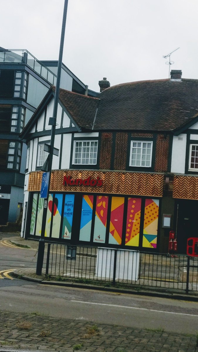 Nando's after redesign. Same red logo as before on a patterned brown back. Hard to read.