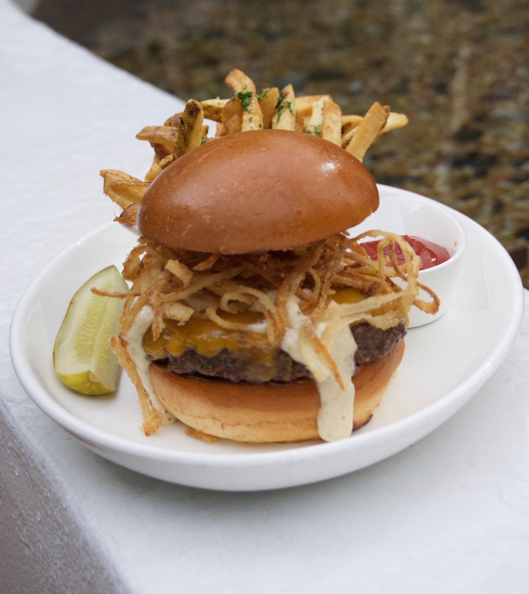 The Marquis Cheeseburger, dressed with crispy onions, cheddar and horseradish pepper sauce.