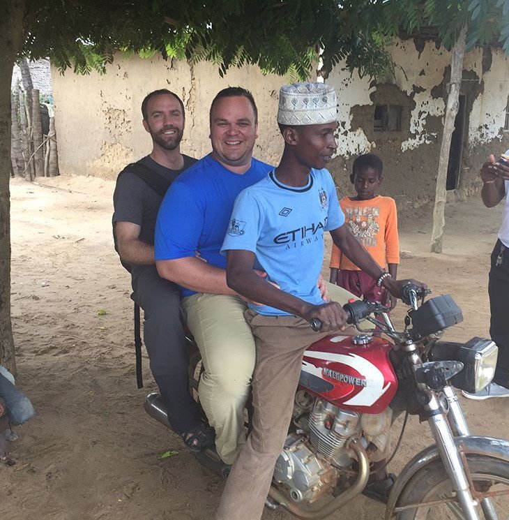 HopeStoryCA's tweet photo. Our fearless leader, Tim Brown, and supporter  @twarden14 trying out local transport in #Tanzania. #TwoTimsOnABoda #BodaBoda @timcogroup https://t.co/hoDYtOWkk2