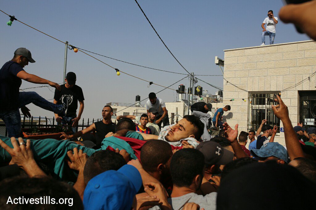 activestills's tweet photo. #NOW: Palestinian youth carry Mohamed Abu-Ganem from Makassed hospital as police raids hospital and burial procession following clashes https://t.co/v3swNOtuU3