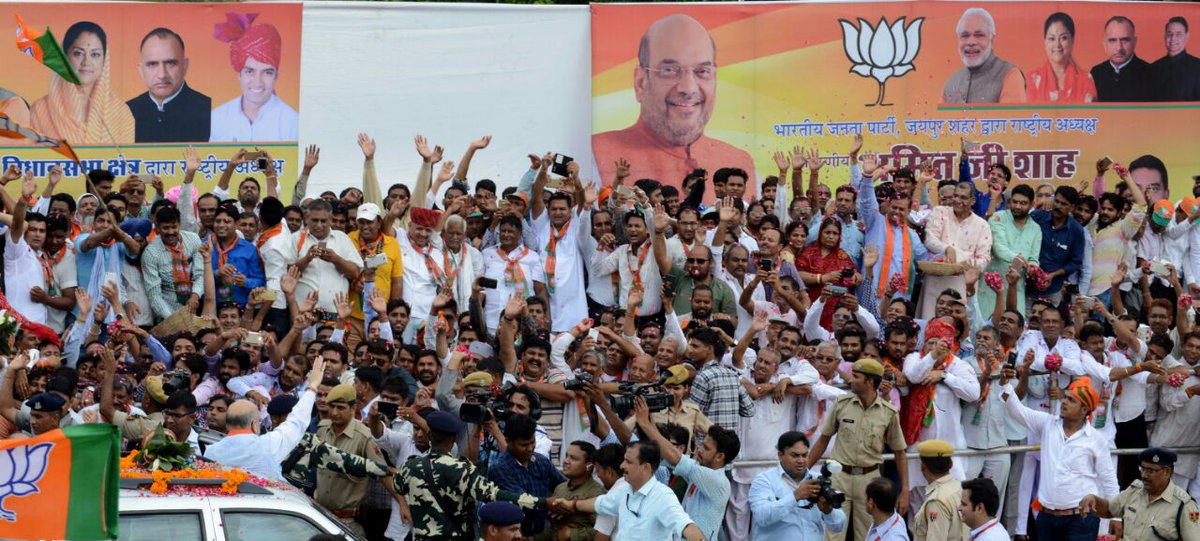 sangpran's tweet photo. Colourful enthusiastic albeit #RainDrenched welcome 2 @AmitShah by @BJP4Rajasthan @VasundharaBJP 
#feedback time &amp; target is 2019 via 2018 https://t.co/E1Z1RIa1Eq