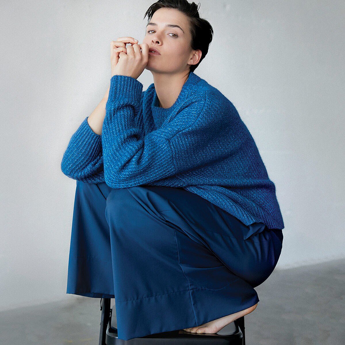 The Lou Sweater has an uplifting mix of glitter yarn and cashmere, in an oversized teal chunky knit, worn over our wide-leg Eiger Pant.