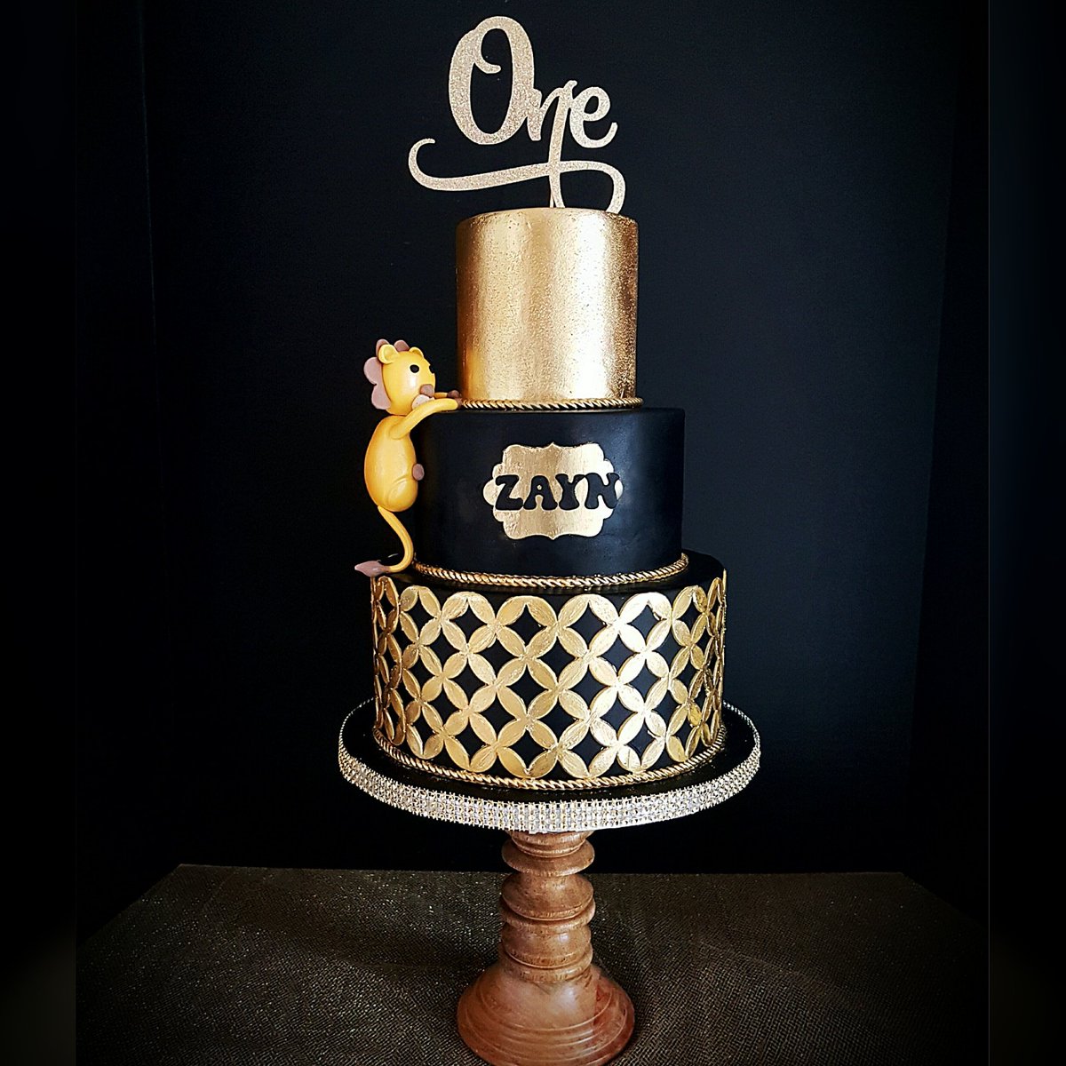 Tawreeda's tweet photo. A bold black and Gold for a 1 year old. Isn't that little lion climbing the cake so cute! ❤️ https://t.co/xHTCgq6KIi