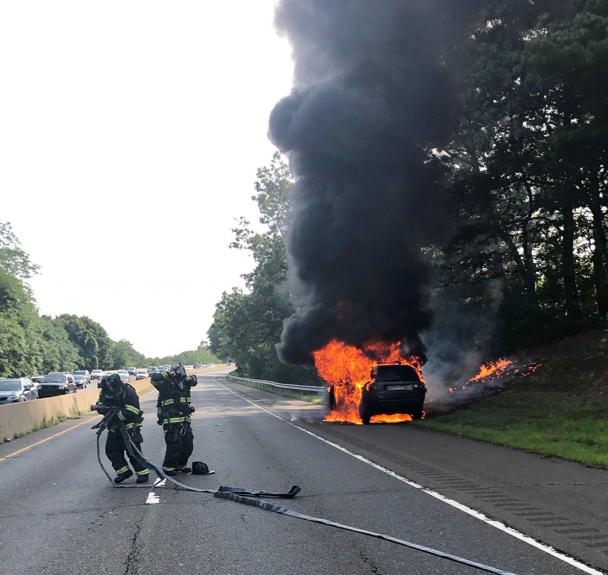 HamdenFireDept's tweet photo. Photo from earlier car fire on RT 15 in #Hamden. Well involved with extension to brush. #E2 crew prepares to extinguish. @IAFFLocal2687 https://t.co/KdVQp3U8r8