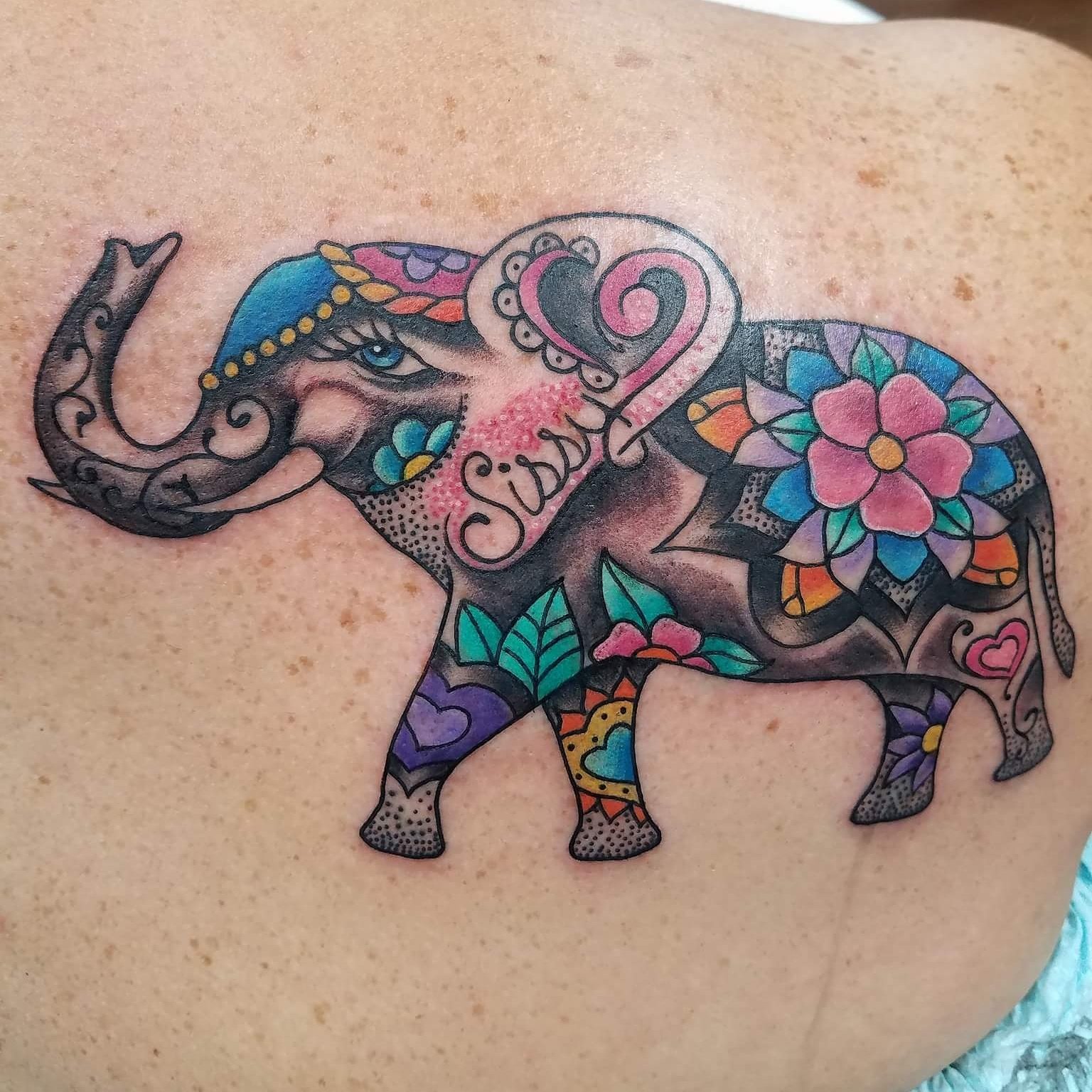 Minimalist line art elephant tattoo on the inner arm.