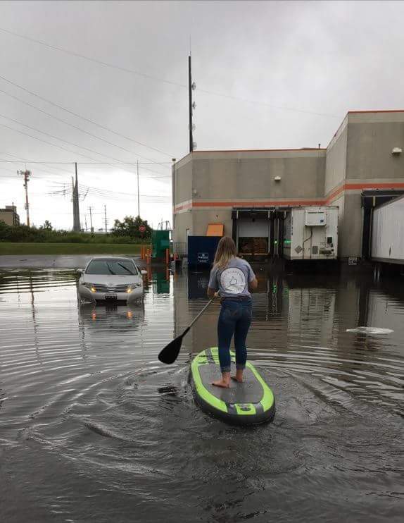 MIHomeYGK's tweet photo. A Bed Bath &amp; Beyond employee paddle boards in the parking at Riocan to assist a stuck vehicle. #ygk https://t.co/cHacLEyQJC