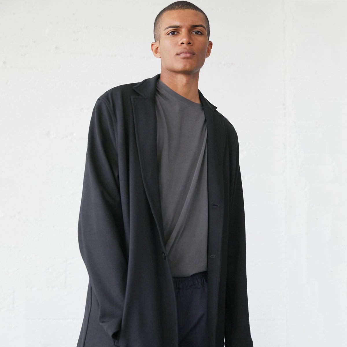 Stealth style. The relaxed unstructured black double-knit Keo coat moves effortlessly, covering a stretch pant and sueded rugby tee.
