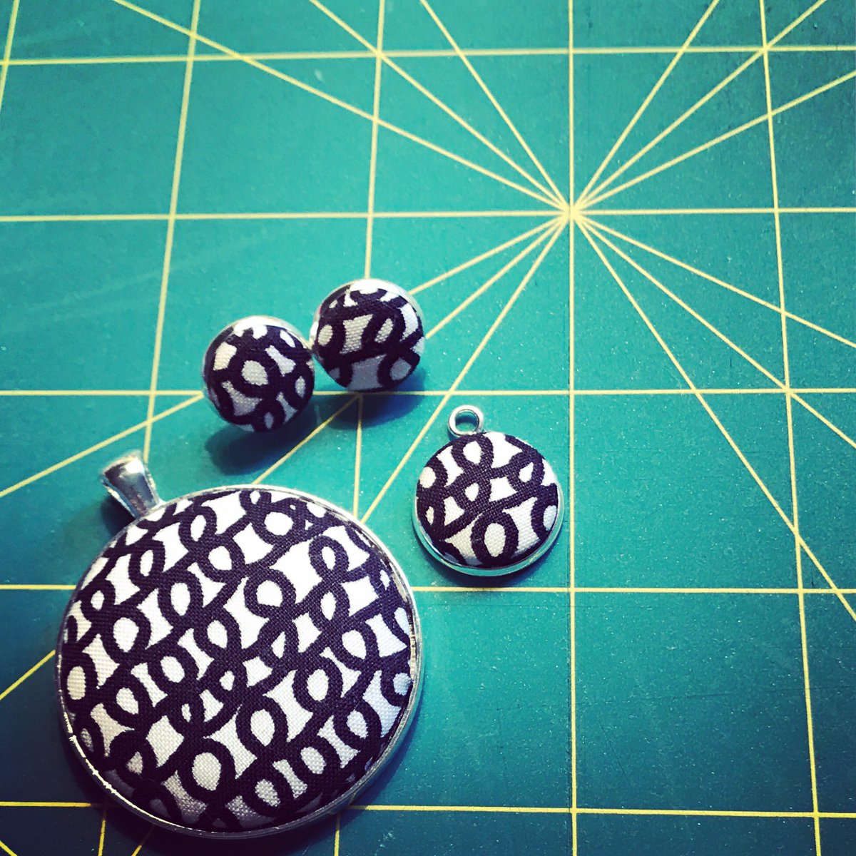 ohhellobug's tweet photo. On the cutting mat last night! New to me fabric made into small and large pendants and small earrings. Love this fabric! #coveredbuttons https://t.co/tXGEcpMWhw
