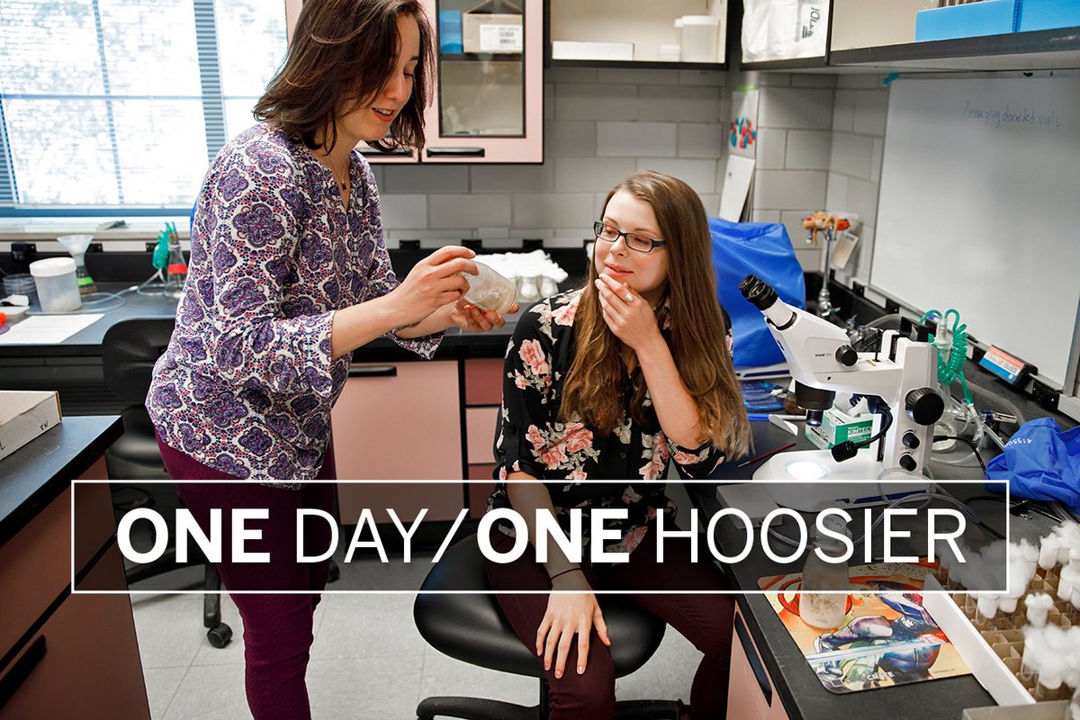 Kaeli Bryant looks at a specimen in a lab with IU researcher Irene Newton with the words "One Day/One Hoosier" superimposed on top of the image
